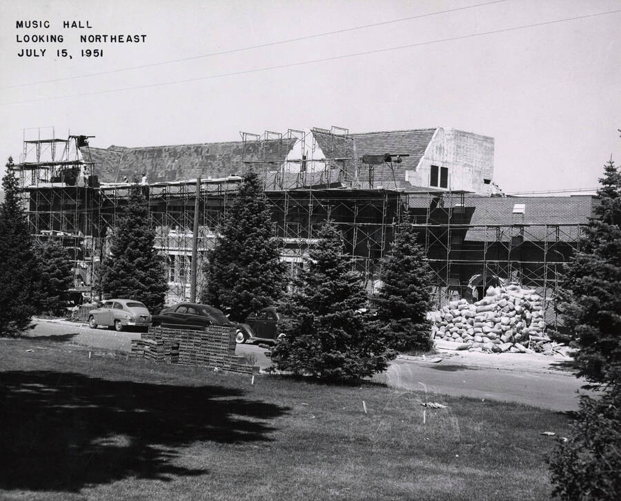 July 15, 1951 photograph of the Music Building under construction. Automobiles in foreground. [PG1_117-26a]