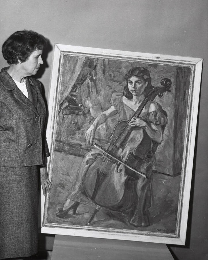 1964 photograph of a painting in the Music Building. Mary Kirkwood, the artist, stands next to her painting of Kathryn Kennard. Donor: Publications Dept. [PG1_117-07]