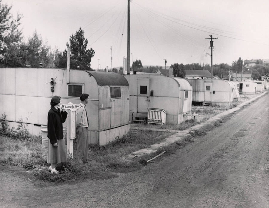 1950 photograph of the Veterans Housing Trailer Village. A man and woman stand to the left. [PG1_120-03]