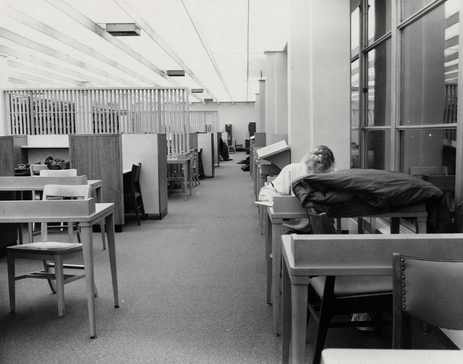 1988 photograph of the Library. A student studies at a desk to the right. [PG1_122-102]