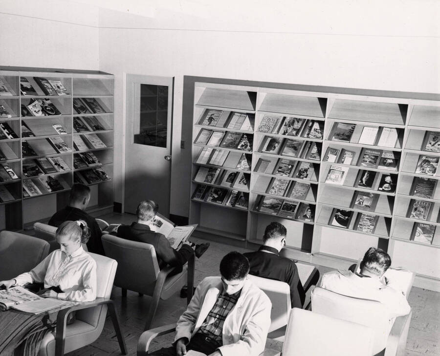 1957 photograph of the Library. Students read newspapers and magazines in foreground. [PG1_122-023]