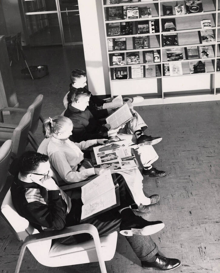1957 photograph of the Library. Students read magazines in foreground. [PG1_122-024]
