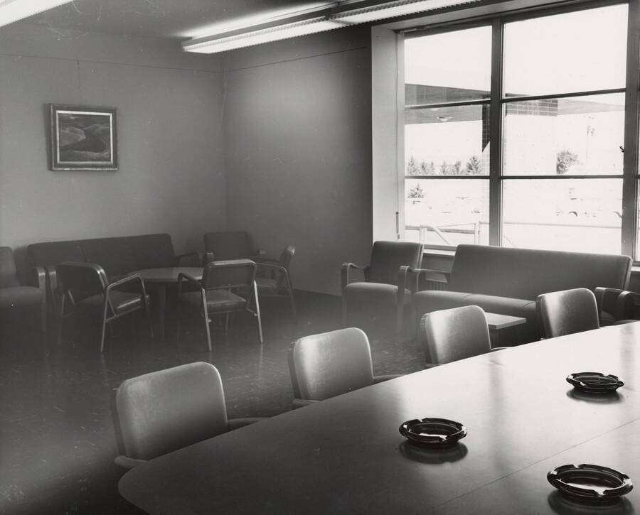 1957 photograph of the Library. Large conference room with ashtrays in foreground. [PG1_122-032]