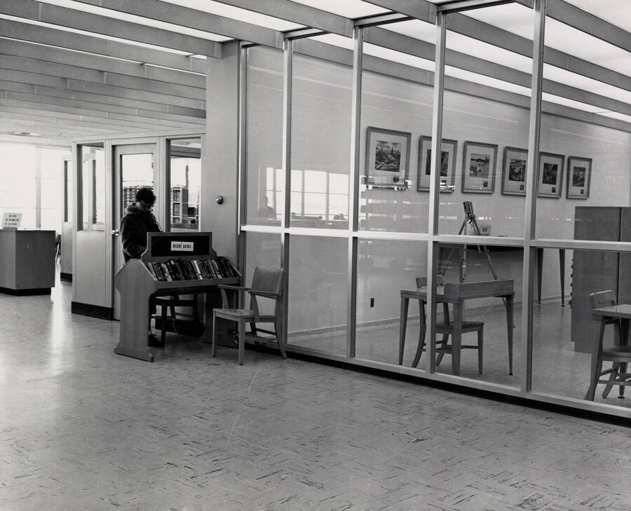 1957 photograph of the Library. A student browses new books on the left. [PG1_122-033]