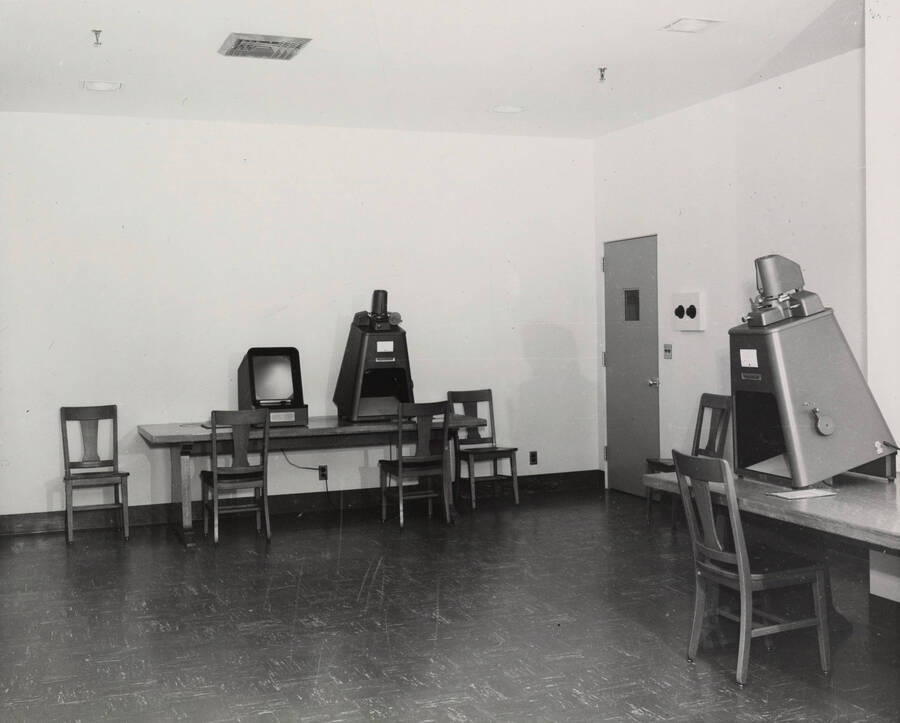 1957 photograph of the Library. Microfilm reading room with several microform machines. [PG1_122-038]