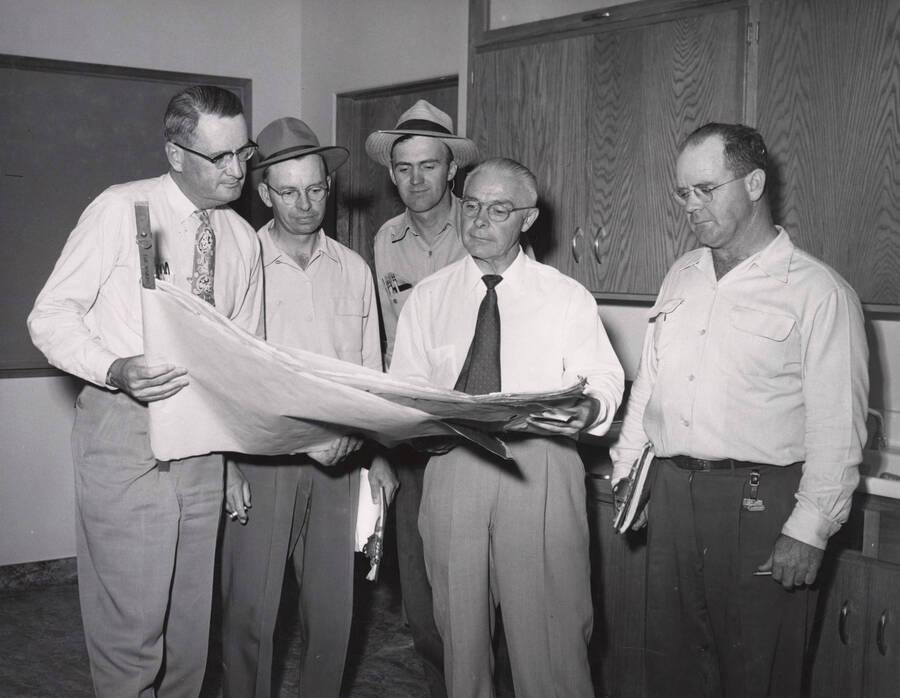 1953 photograph of the Home Economics Building. Left to right: J.E. Buchanan, George gain, E.H. Nelson, Howard Gates, E.L. Bartlett inspect the building. [PG1_123-01]
