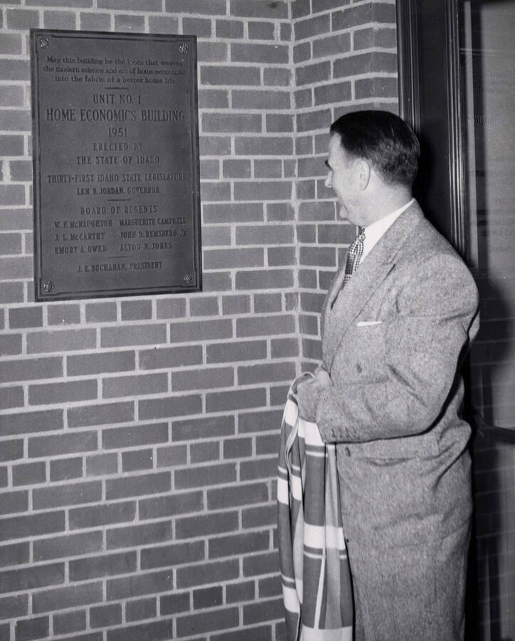 1953 photograph of the Home Economics Building dedication ceremony. Regent J. L. McCarthy at dedicatory plaque. [PG1_123-05]
