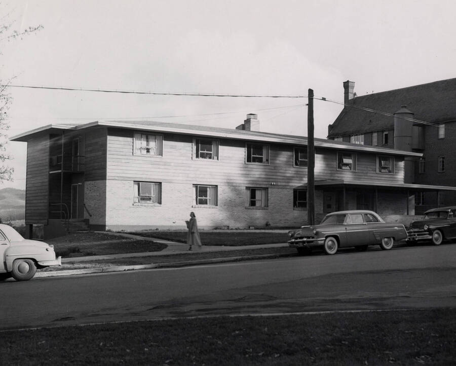 1950 photograph of the Ethel Steel House. Automobiles and a student in the foreground. [PG1_124-05]