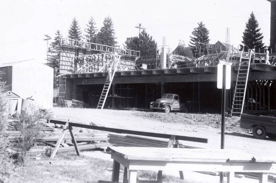 1960 photograph of the Mines Building under construction. Automobiles and construction workers in foreground. Donor: College of Mines. [PG1_125-07]