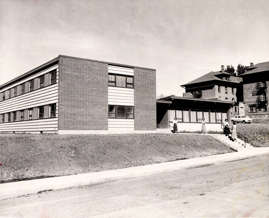 1954 photograph of the Permeal J French House. Students in foreground, Ridenbaugh Hall in background. Donor: Publications Dept. [PG1_126-06]