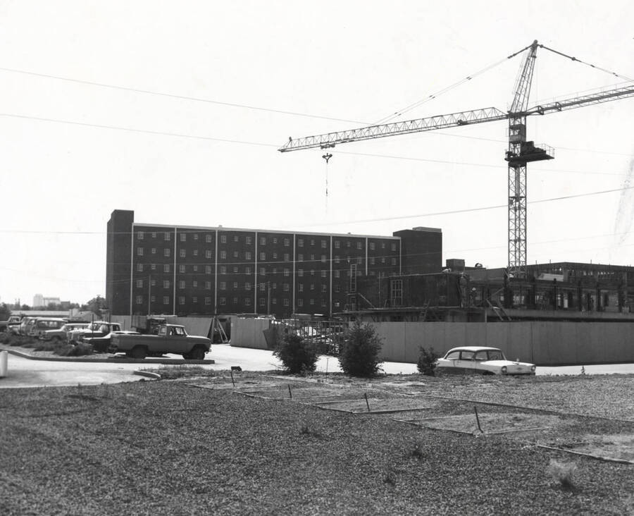 1965 photograph of the Willey Wing, Wallace Residence Center, under construction. Automobiles in foreground. Donor: Publications Dept. [PG1_129-c]