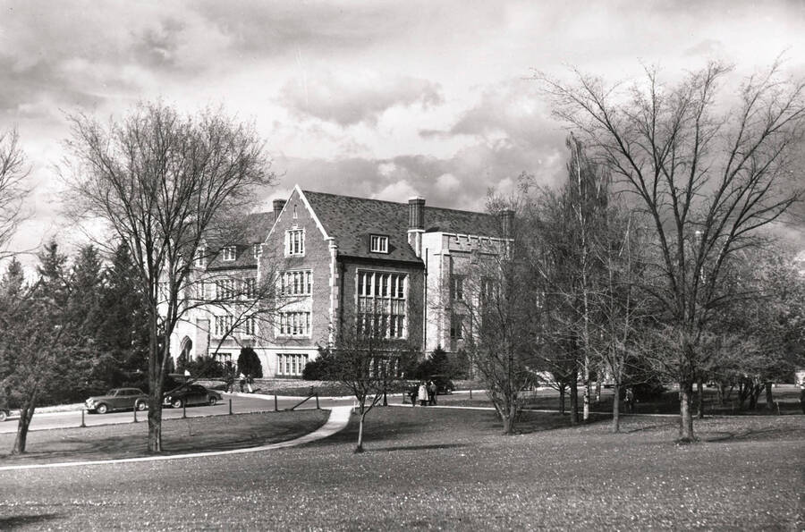 1956 photograph of Life Sciences Building. Trees in foreground, students approach the building. Donor: Publications Dept. [PG1_132-03]