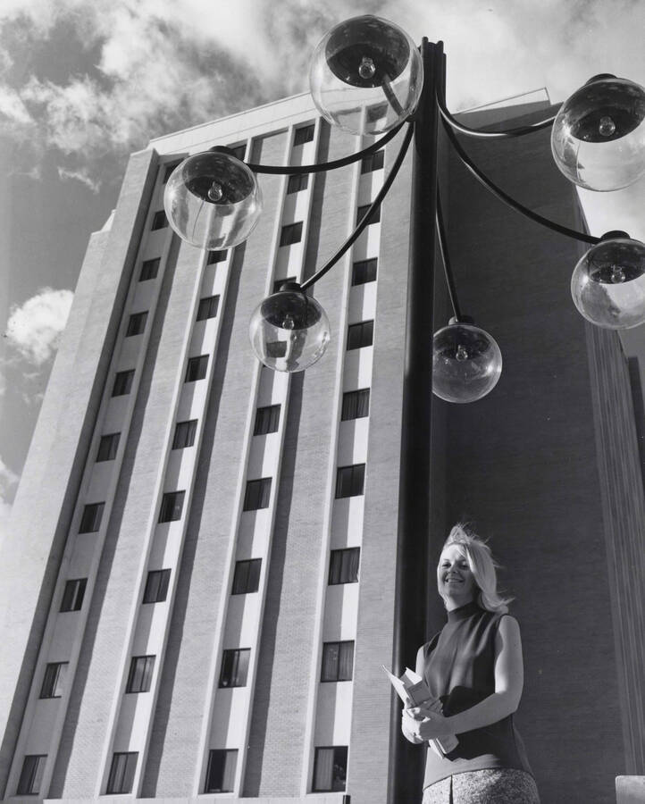 1969 photograph of the Donald R Theophilus Residence Hall. Student in foreground next to lamp post. Donor: Publications Dept. [PG1_134-05]