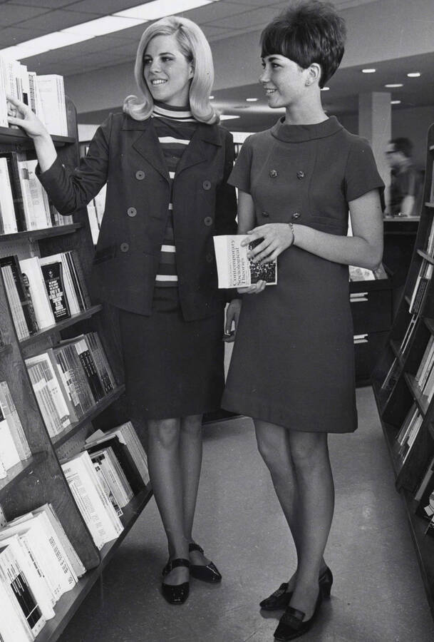 1966 photograph of the University Bookstore. Two female students browse books. [PG1_135-02]