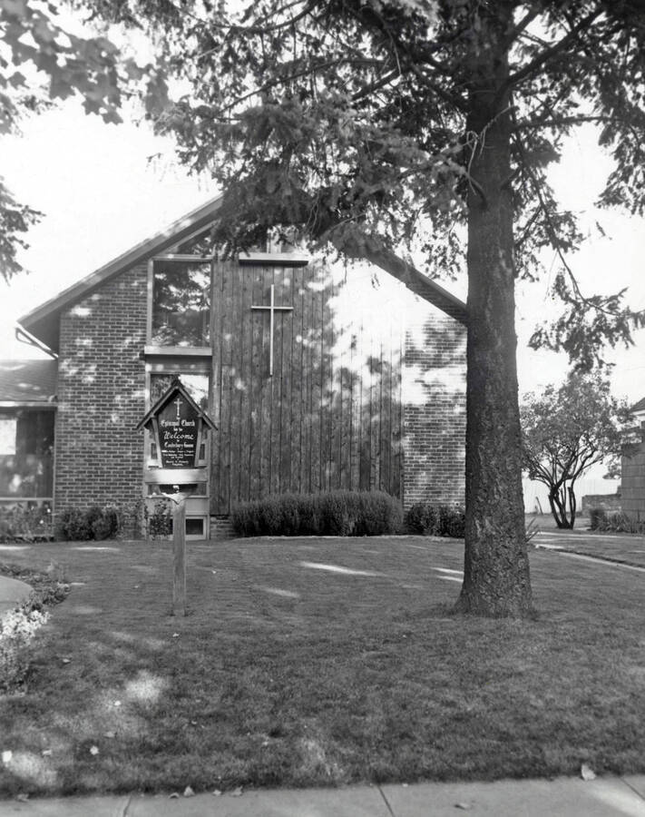 1960 photograph of the Canterbury House Episcopal Student Center. Large tree in foreground. Donor: Photo Center. [PG1_144-01]
