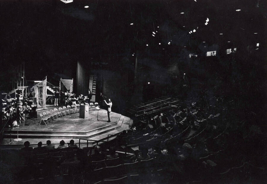 1974 photograph of the Hartung Theatre dedication ceremony. A conductor leads a small group of musicians. [PG1_145-10]