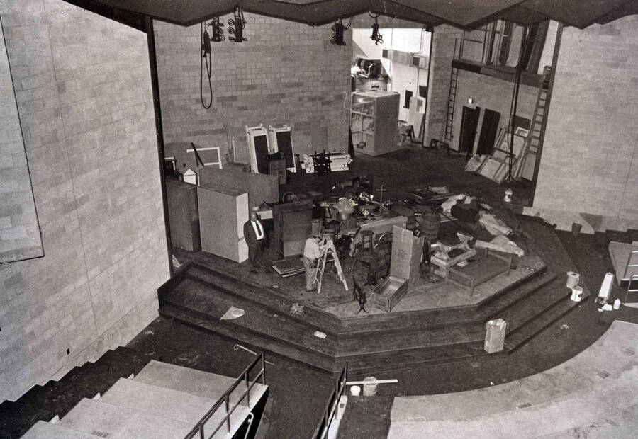 1975 photograph of Hartung Theatre. Students build a set on stage. [PG1_145-15b]