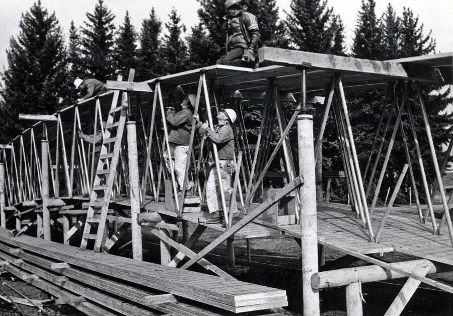 1975 photograph of the Kibbie-ASUI Activity Center under construction. Construction workers in foreground. [PG1_147-14]