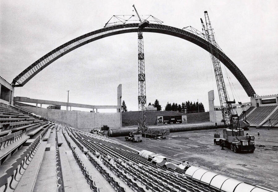 1975 photograph of the Kibbie-ASUI Activity Center under construction. Large cranes in foreground. Donor: U of I Alumni Office. [PG1_147-29]