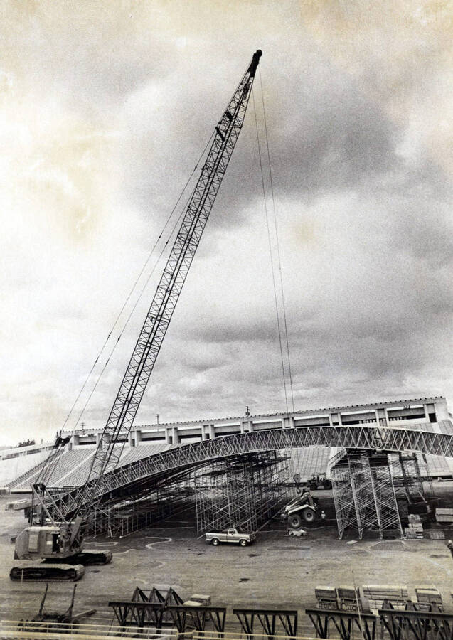 1975 photograph of the Kibbie-ASUI Activity Center under construction. Large crane in foreground. [PG1_147-09]