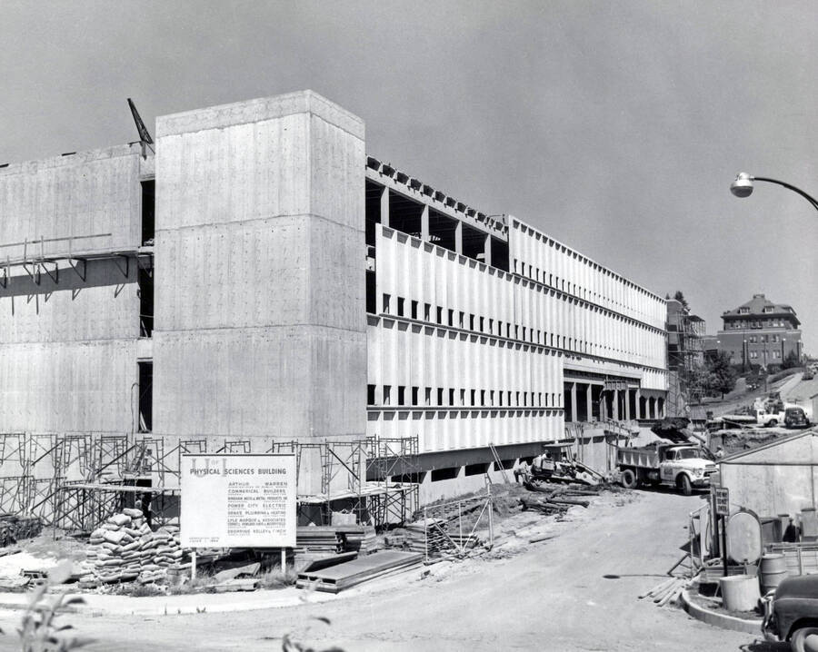 1963 photograph of Renfrew Hall (Physical Science Building) under construction. Automobiles in foreground and background. Donor: Publications Dept. [PG1_148-02]