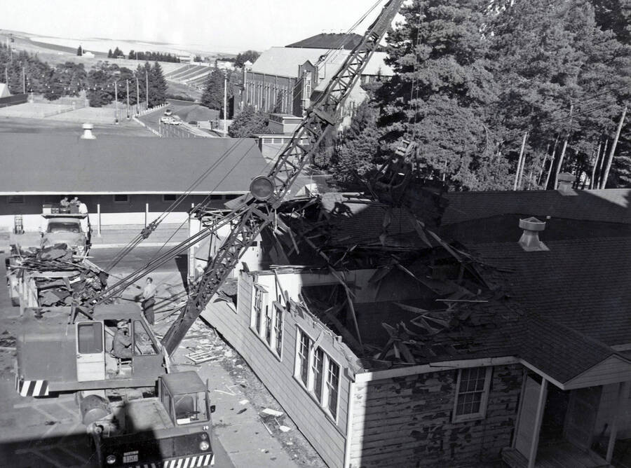 1966 photograph of Temporary Classroom Building #1 under demolition. Memorial Gym in background. Donor: Publications Dept. [PG1_152-01]