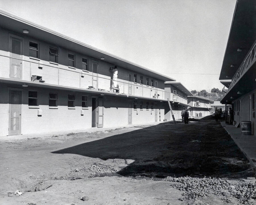 1957 photograph of the Park Village Apartments under construction. Construction workers in background. Donor: Publications Dept. [PG1_154-01]