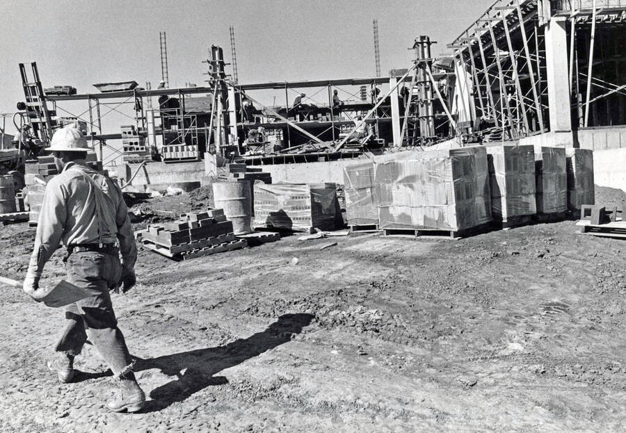 September 15, 1972 photograph of the Menard Law Building under construction. Construction worker in foreground. [PG1_162-04]