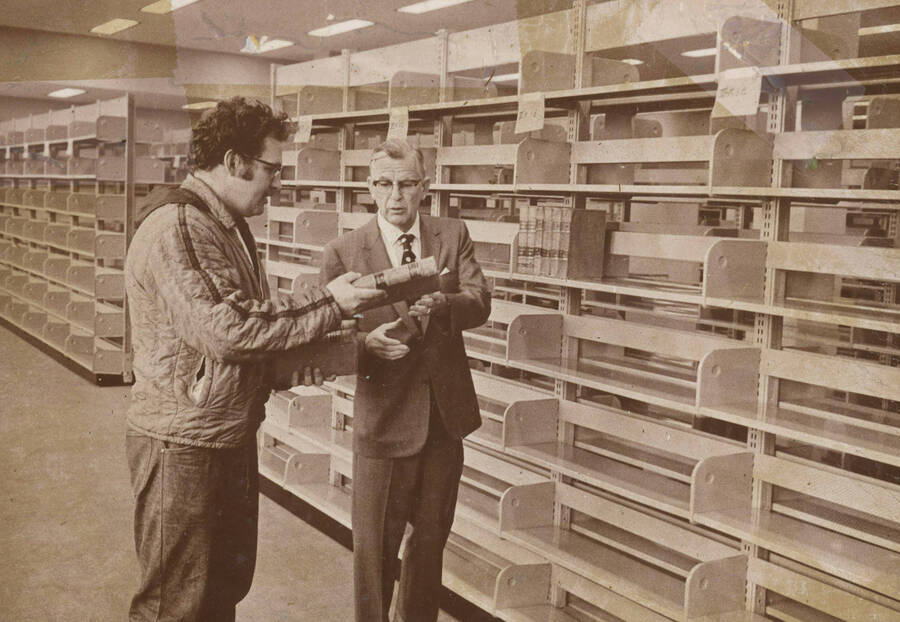 1974 photograph of the Law Library. Dean Menard shelves books in the new library. [PG1_202-12]