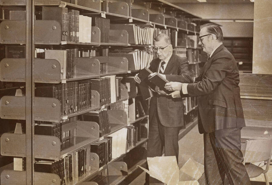 1974 photograph of the Law Library. Dean Menard and Walter H. McLeod shelve books in the new library. [PG1_202-13]