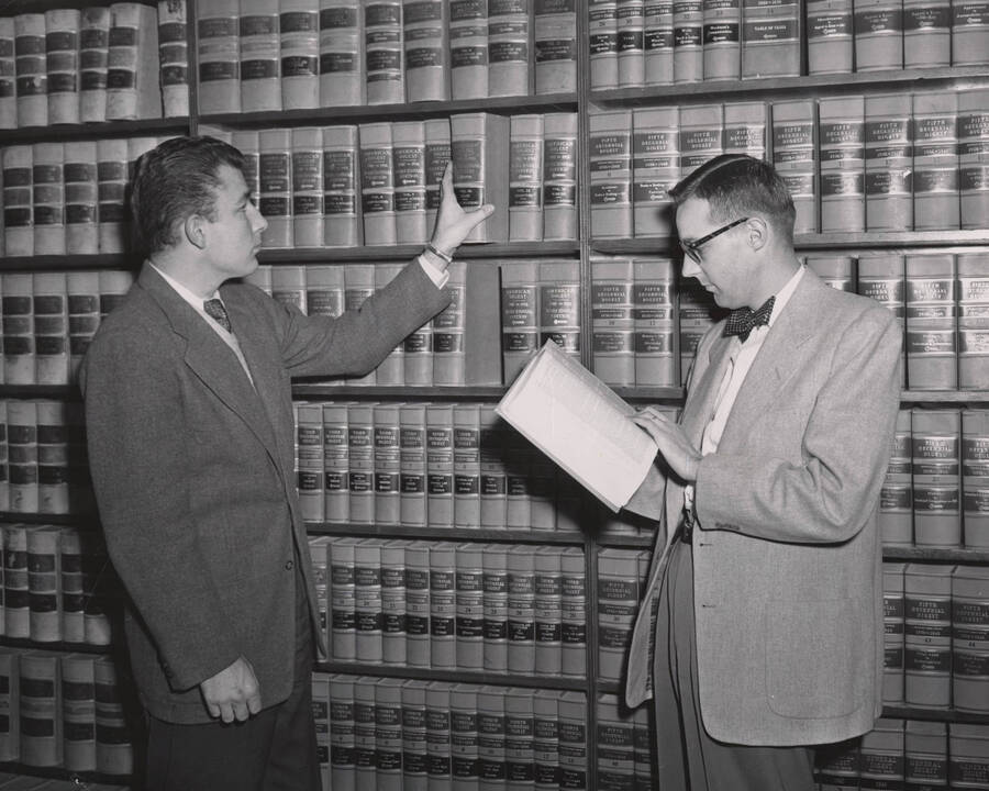 1940 photograph of the Law Library. Two students browse law texts. Donor: Publications Dept. [PG1_202-08]