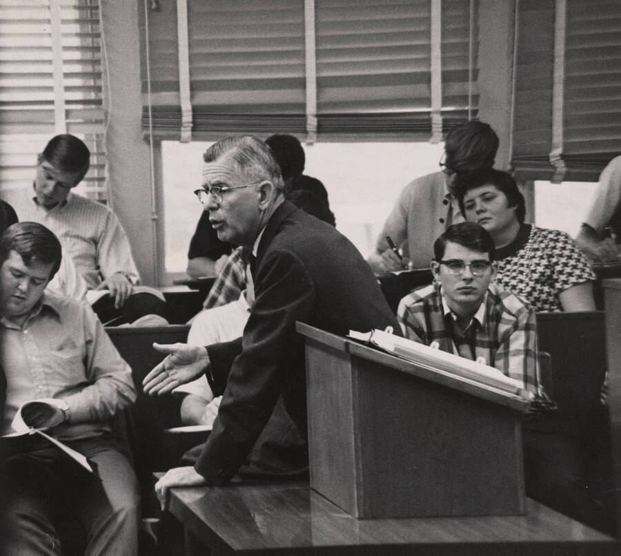 1965 photograph of the College of Law. Students take notes during a lecture. [PG1_203-14]
