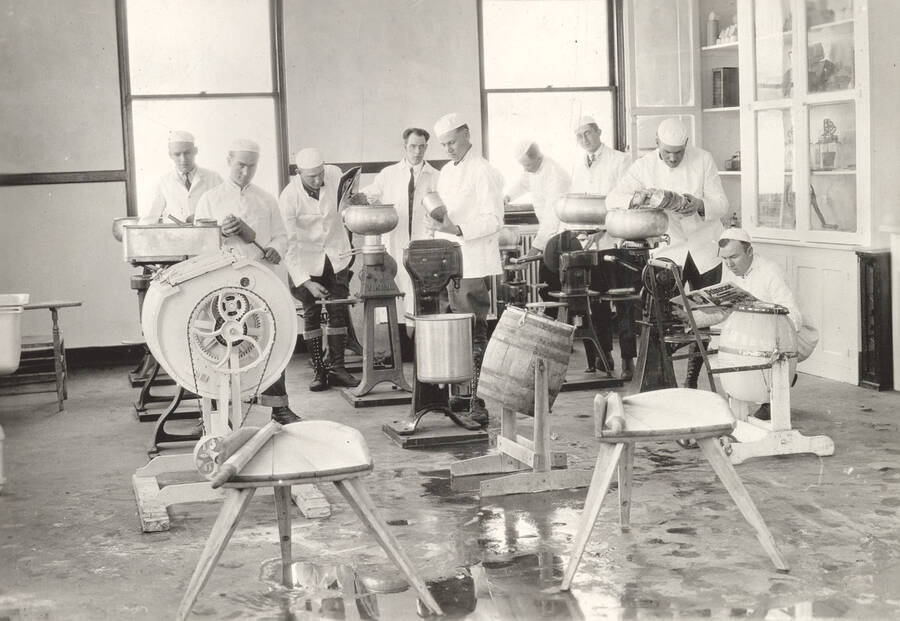 1925 photograph of Dairy Farm and Creamery. A class of students study cream sperators. [PG1_205-18]