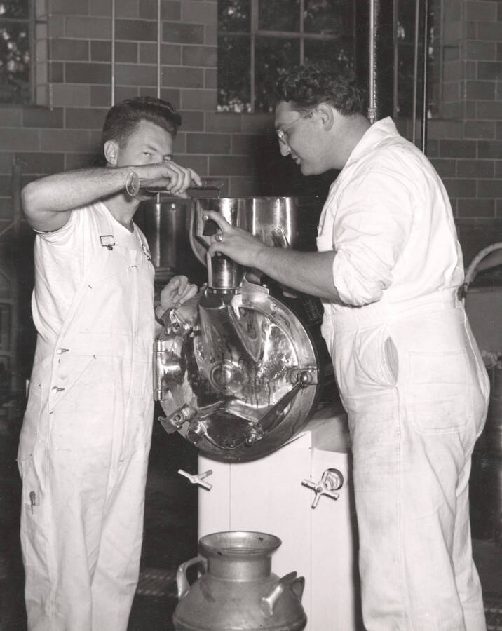 1953 photograph of Dairy Farm and Creamery. Students operate an ice cream machine. Donor: Publications Dept.. [PG1_205-35]