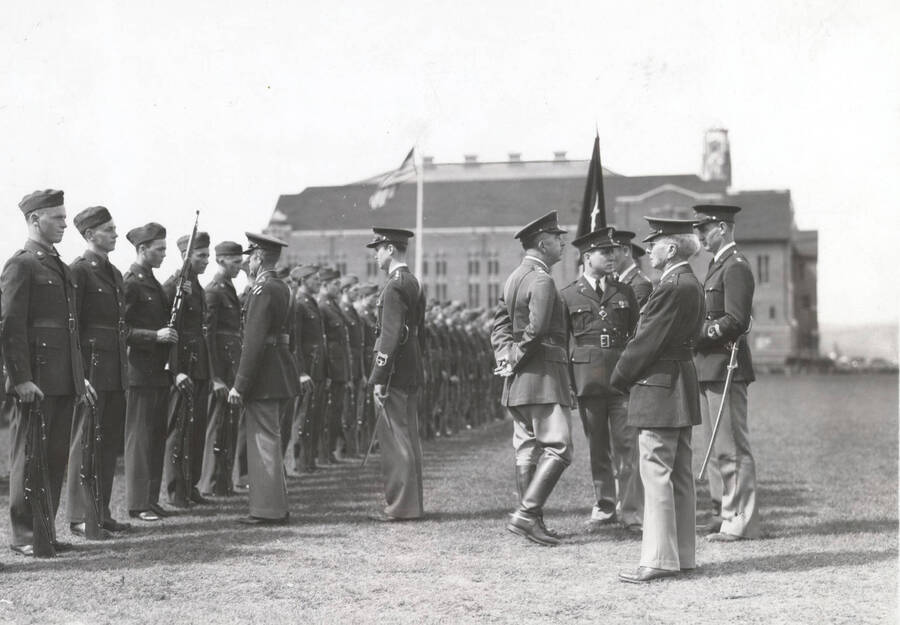 1936 photograph of Military Science Cadets. Cadet battalion in formation during a review. University building in background. [PG1_208-010]