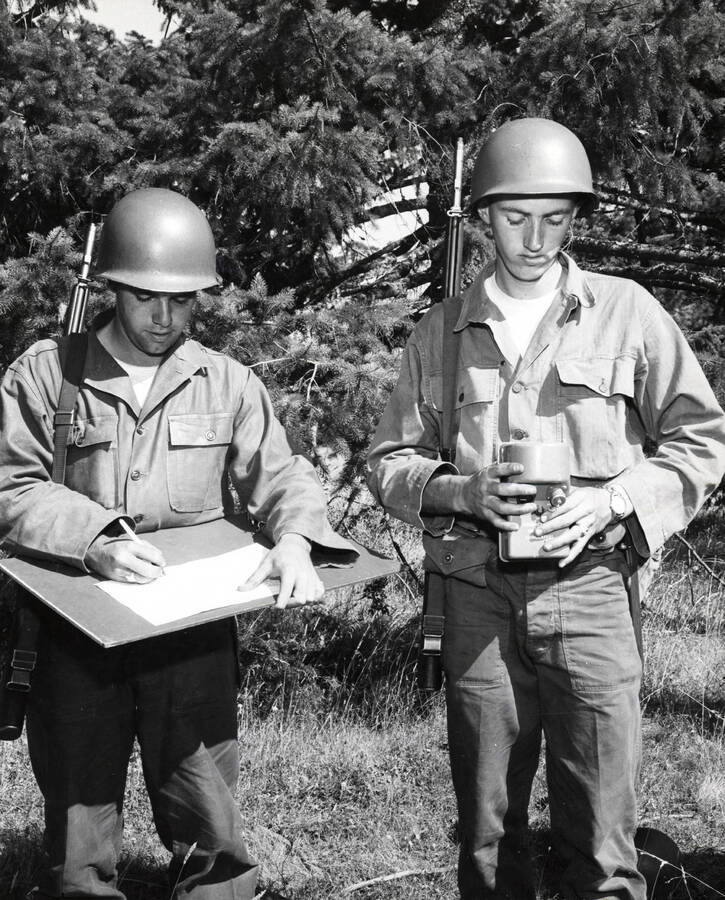 1960 photograph of Military Science Cadets. Cadets Randolph L. Smith (Arizona State) and Robert Rowland (UofI) participate in CBR training exercise. Donor: Army ROTC. [PG1_208-108]