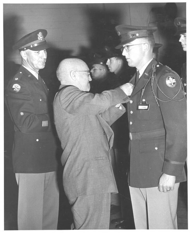 Military Science. University of Idaho. Cadet Chaney being pinned by president Theophilus. [208-129]