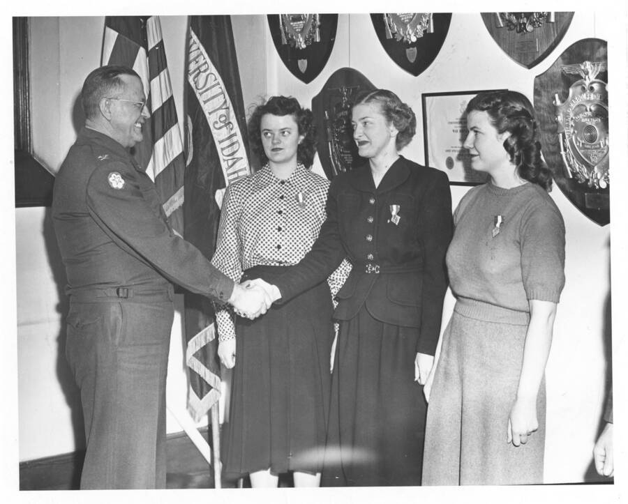 1948 photograph of Military Science Cadets. An officer greets the Women's Rifle Team in an office. [PG1_208-147]