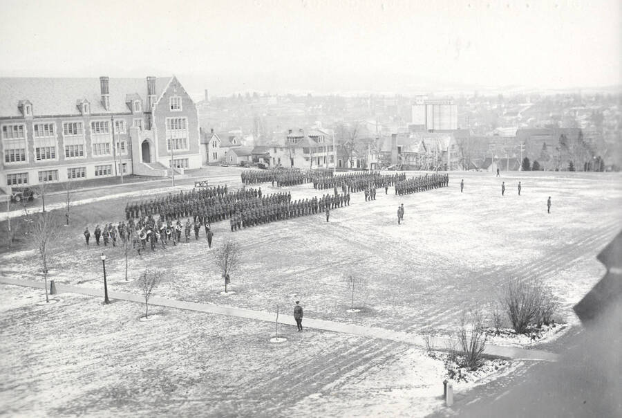 1925 photograph of Military Science Cadets. Military cadets on review in front of the Sience Hall with campus buildings in the background. [PG1_208-035]
