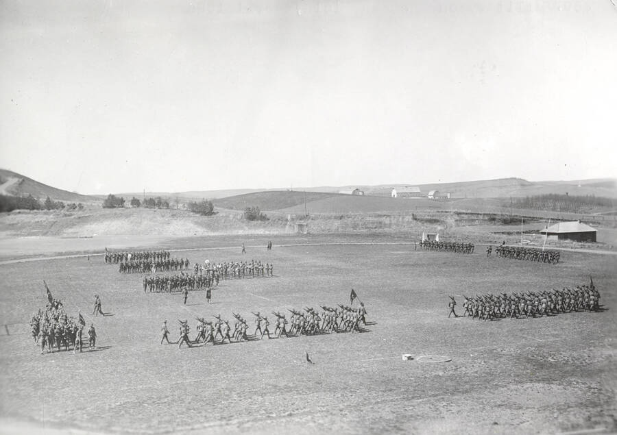 1926 photograph of Military Science Cadets. Military cadets on parade at Maclean field. University farms are visible in the background. [PG1_208-037]