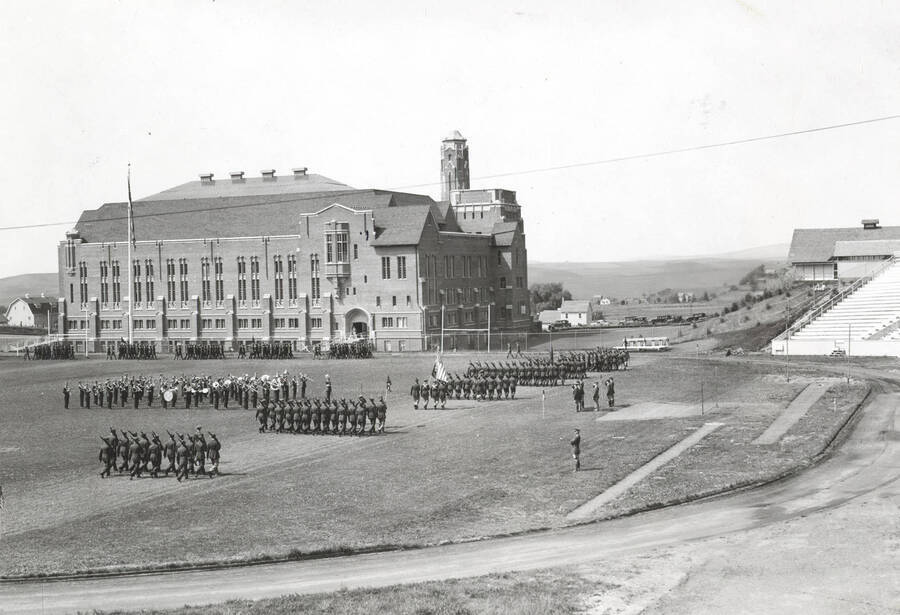 1936 photograph of Military Science Cadets. Military cadets on parade at MacLean Field. Administration building visible in the background. [PG1_208-044]