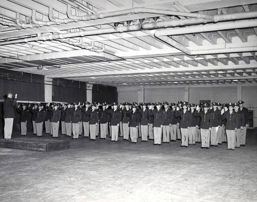1953 photograph of Military Science Cadets. Class of 1953 cadets receiving oath from Major Woods. [PG1_208-082]