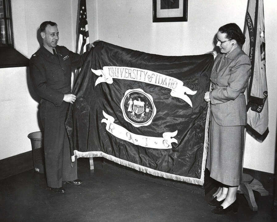 1948 photograph of Military Science Cadets l-r: Col. Blewett, Miss Morin. Retiring the University of Idaho flag. [PG1_208-083]