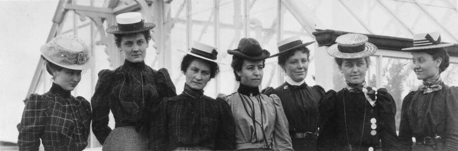1899 photograph of Plant Sciences. Five female students outside a greenhouse. l-r: Effie May Wilson, Sadie Mae Skattaboe, Pauline J.Moerder, Mary C. McFarland, Carrie A. Tomer, Grace E. Woodworth, Minnie G. Marcy. nitrate film. Donor: Grace Woodworth Weber. [PG1_210-10]