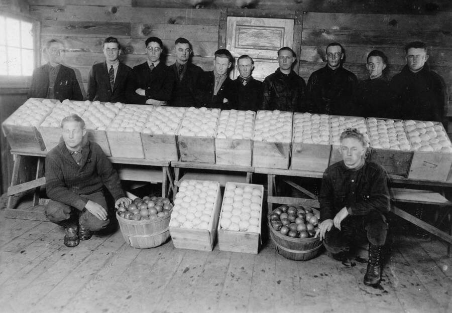 1926 photograph of Plant Sciences. Twelve students with barrels and boxes of produce. [PG1_210-07]