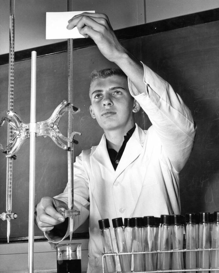 1960 photograph of Chemistry Class. D. Deton operates an experimental apparatus. [PG1_211-12]