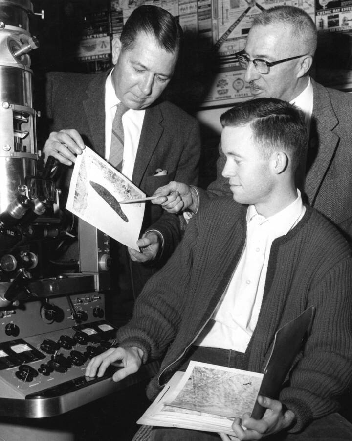 1961 photograph of Chemistry Class. J. Irving Jolley, Emmett E. Spiker, and Pete Kelly examine an electron microspore. Donor: Publications Dept. [PG1_211-17]