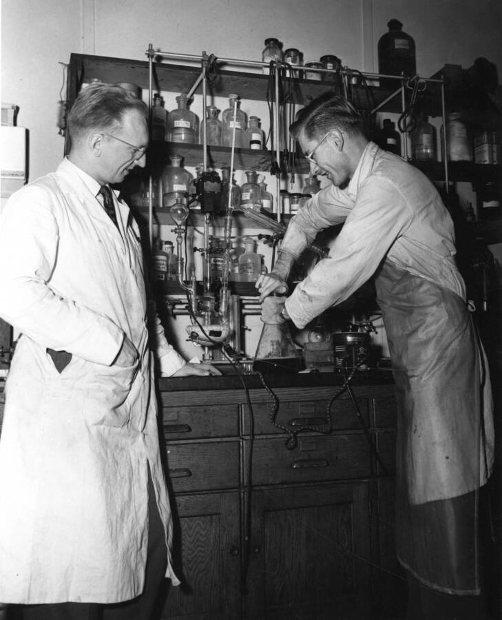 1961 photograph of Chemistry Class. E. K. Raunio and Herbert Schroeder working at a lab table. Donor: Publications Dept. [PG1_211-19]