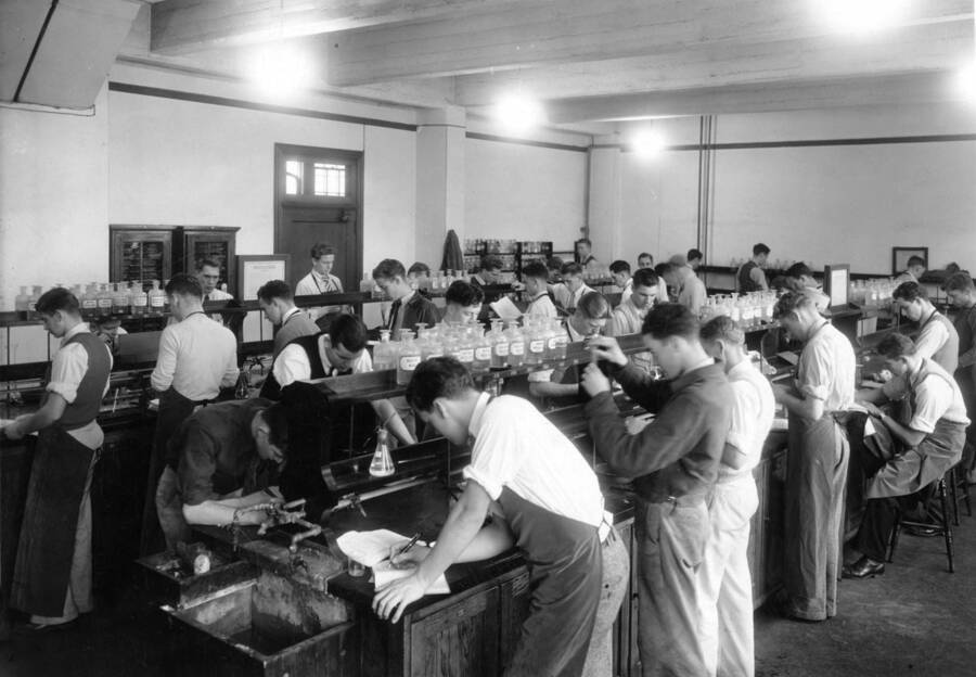 1935 photograph of Chemistry Class. Students working at laboratory tables in the chemistry lab. [PG1_211-02]