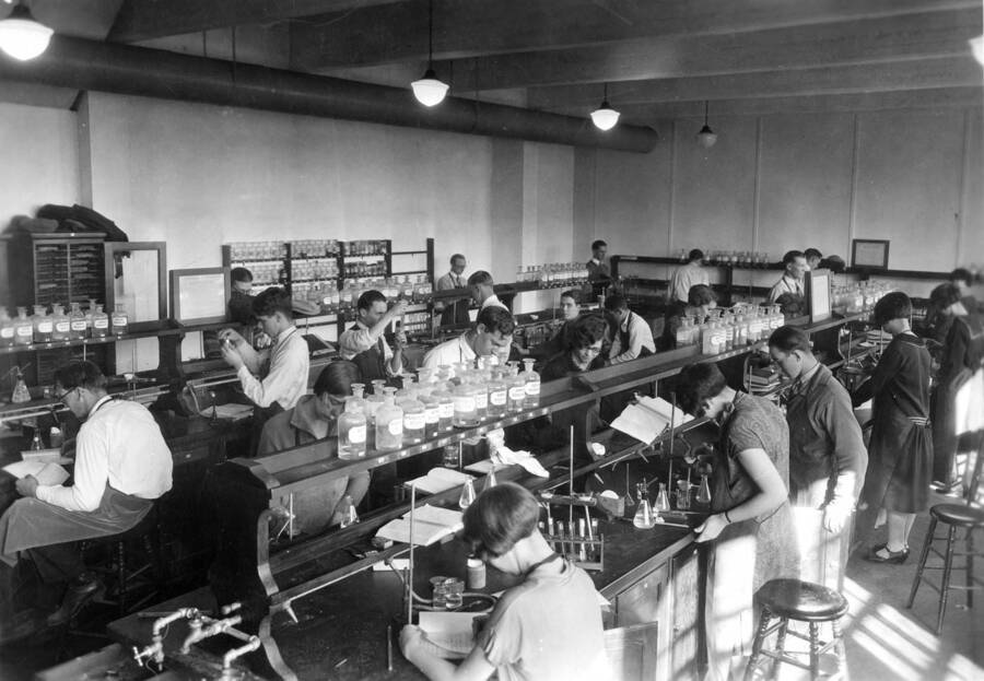 1935 photograph of Chemistry Class. Freshmen students working at laboratory tables in the chemistry lab. [PG1_211-03]